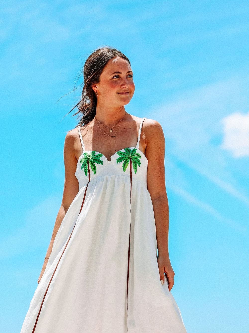 Stylish women's strappy summer dress featuring a vibrant tropical palm print, a must-have for beach holidays.