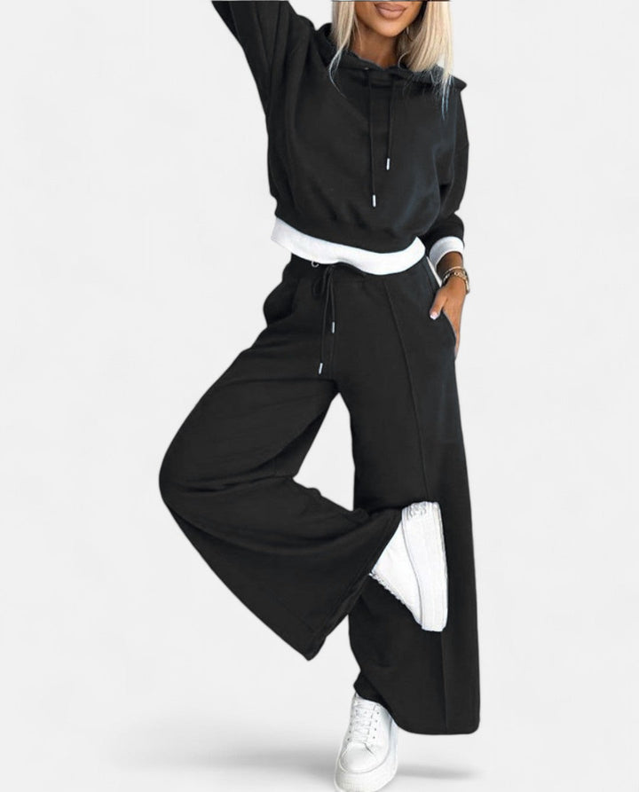 Comfortable women's two-piece sweat set with a modern two-tone hoodie and wide-leg pants, perfect for athleisure.