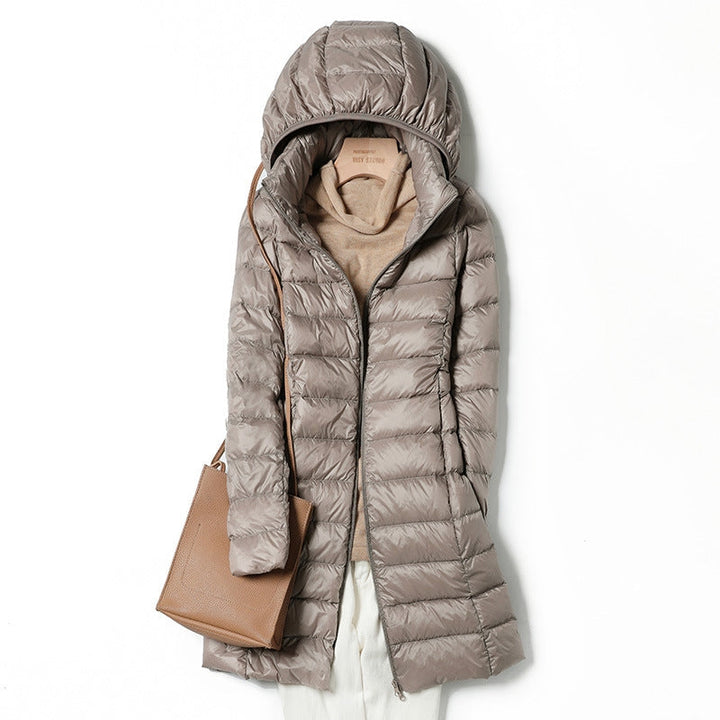 Lightweight women's puffer jacket with hood, insulated for winter warmth, stylish outerwear.