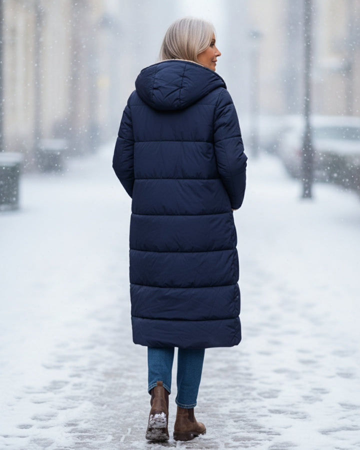 Women's warm quilted outerwear. Long winter coat for elegant cold weather fashion.