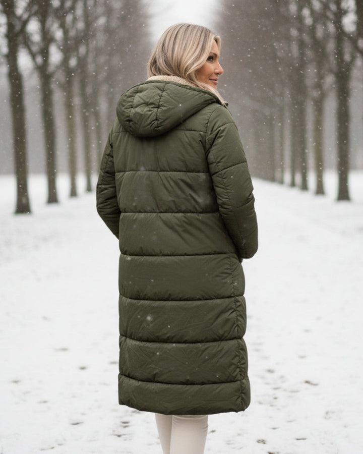 Warm women's quilted winter coat. Long design for elegant cold weather fashion and seasonal wear.