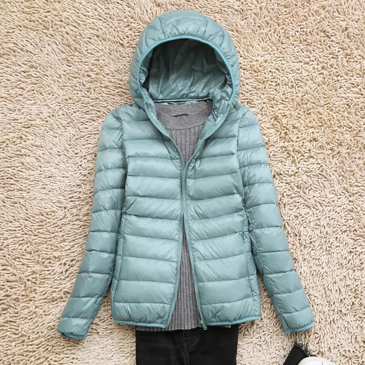 Warm & packable women's jacket, ultralight, insulated hood, ideal for cold weather.