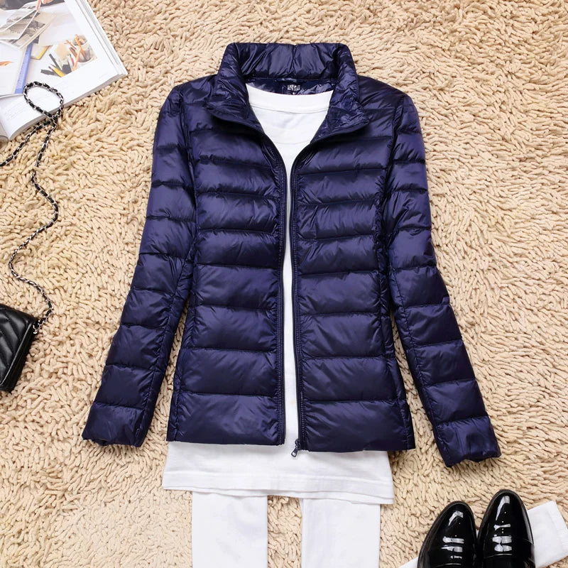Lightweight women's zippered jacket, insulated hood, packable, perfect for outdoor gear.