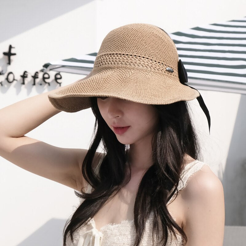 Stylish women's straw sun hat with ponytail opening for UV protection, perfect for summer