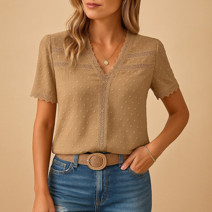 Women's V-neck blouse with delicate lace trim & textured dots. Short sleeve, elegant summer top.