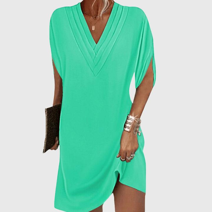 Elegant women's V-neck mini dress featuring short sleeves & a loose cocoon fit, great for warm weather outfits.