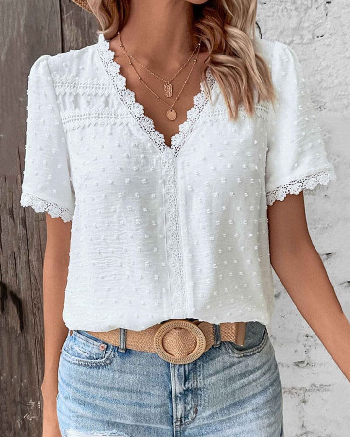 Women's V-neck Swiss dot top with delicate lace trim. Perfect for summer casual or boho chic style.