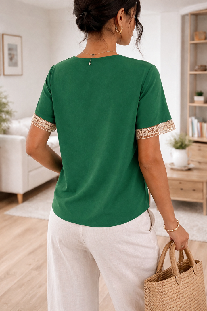 Close-up of elegant lace trim detail on a women's V-neck blouse, showcasing intricate, delicate patterns.