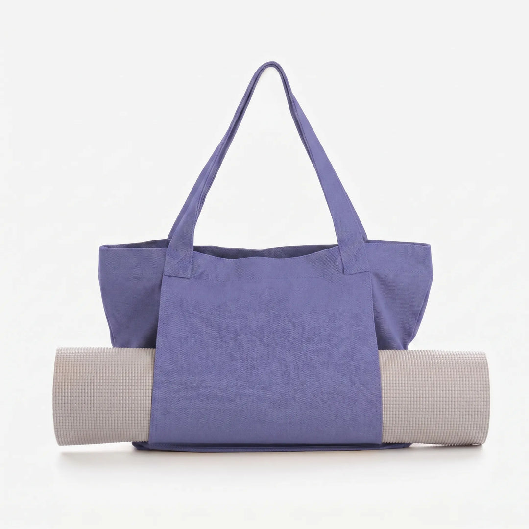 Woman carries a versatile canvas yoga mat tote bag, ideal for gym, fitness, and yoga classes.