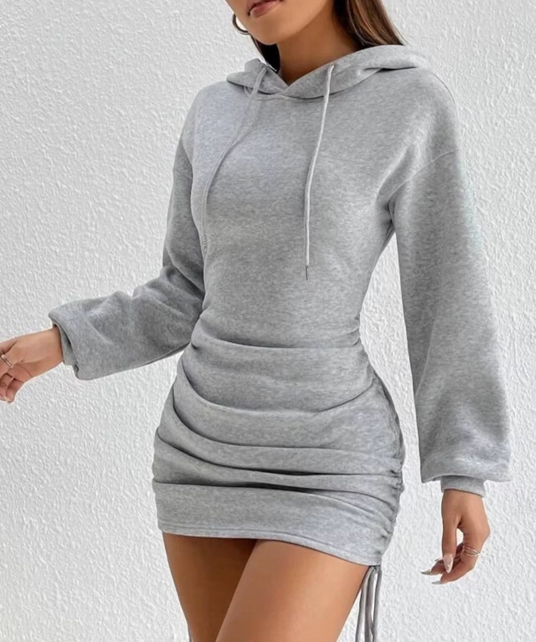 Close-up of the adjustable ruched side detail on a comfortable women's hoodie dress. Versatile fashion.