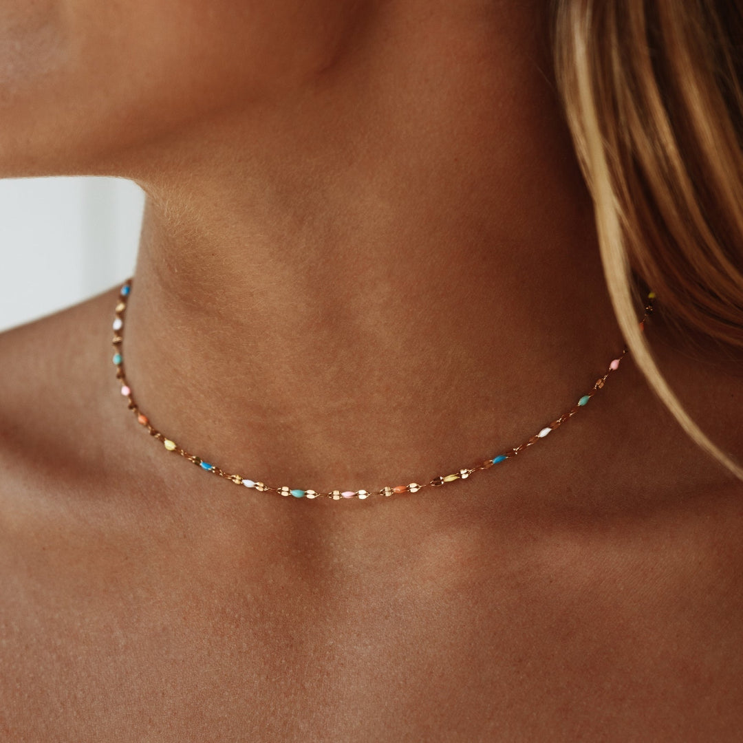 Women's vibrant rainbow choker necklace with colorful enamel, a trendy and eye-catching fashion accessory.