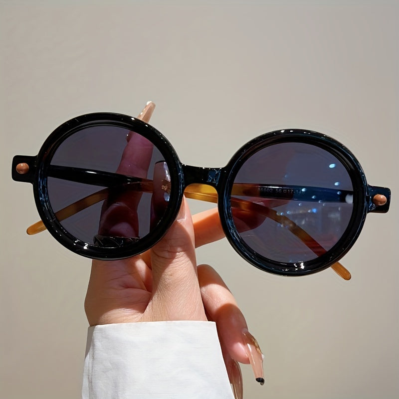 Close-up of women's retro circular sunglasses, showcasing UV400 lenses and stylish frame.