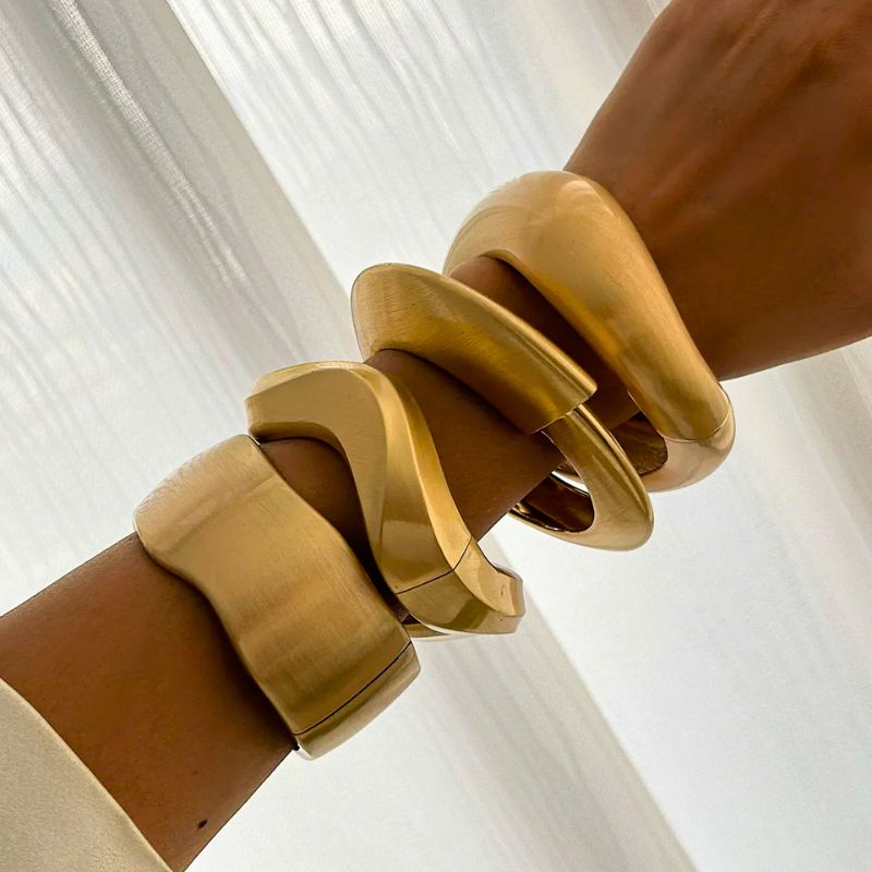 Fashionable women's vintage gold cuff bracelet set with a unique brushed finish and organic design.
