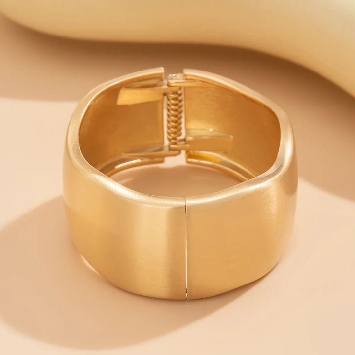 Women's gold cuff bracelet set with brushed metal texture and an elegant organic, vintage-inspired design.