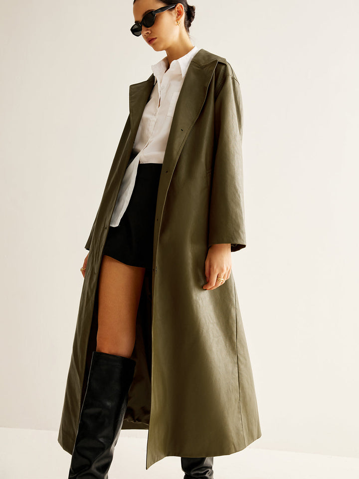 Full-body view of a woman confidently wearing the chic vintage green longline leather jacket.