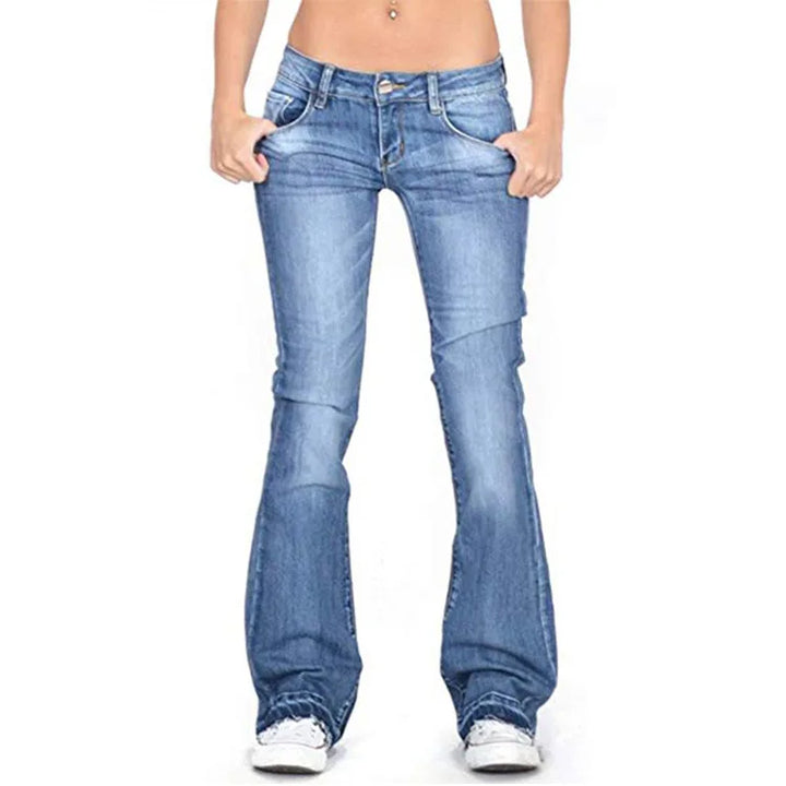 Woman walking in dark blue low-rise flared jeans, embodying retro chic comfort and everyday wear.