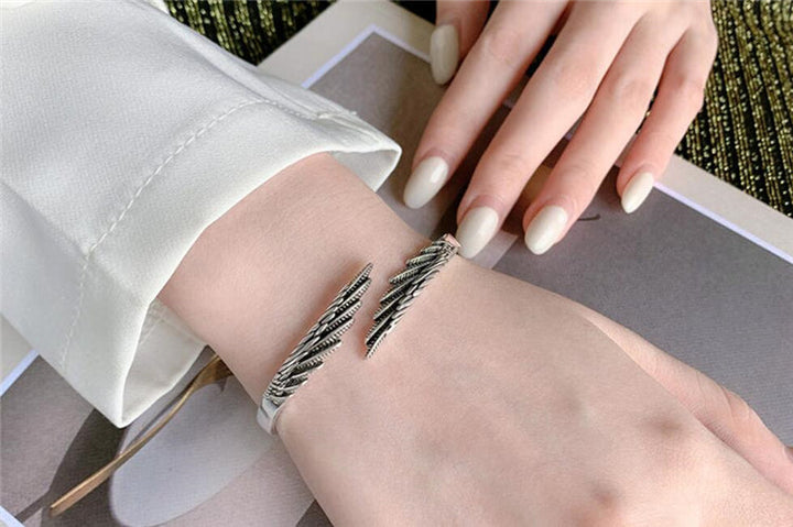 Adjustable sterling silver feather bracelet for women, vintage boho style, a unique and meaningful fashion accessory.
