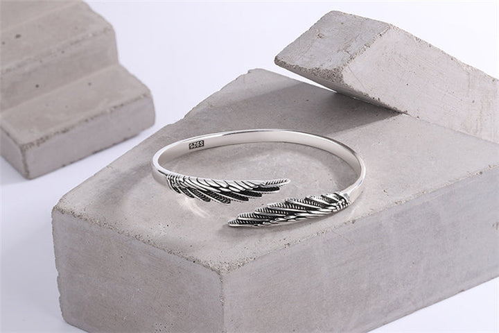 Women's adjustable sterling silver feather bracelet, vintage-inspired cuff, ideal as a boho gift or fashion accessory.
