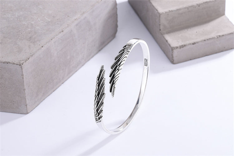 Vintage sterling silver feather bracelet for women, adjustable cuff style, essential boho jewelry & fashion accessory.