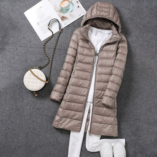 Stylish women's long puffer jacket with a warm hood. Essential cold weather outerwear for ultimate winter comfort.