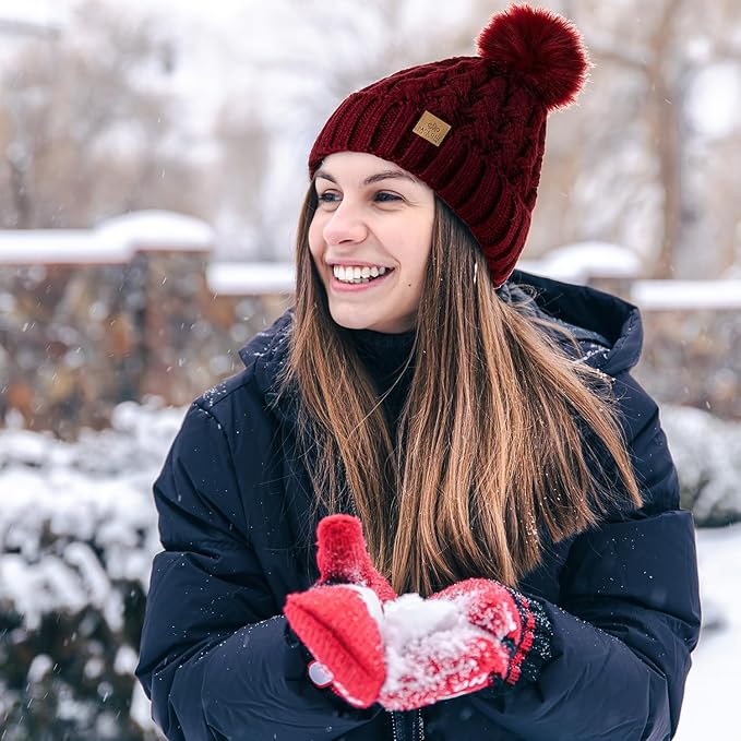 Folded Yvonne knit pom beanie, displaying its compact and warm design for easy storage.