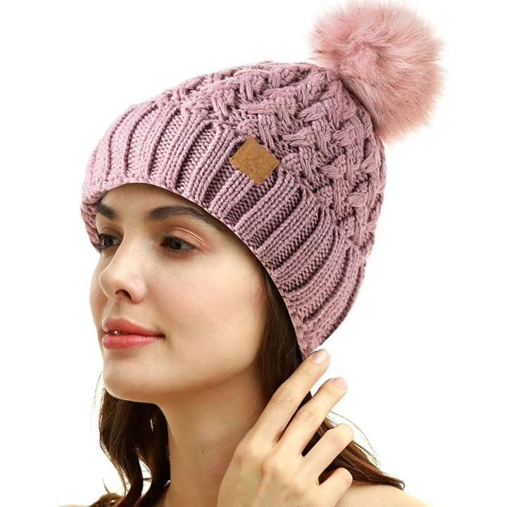 Model wearing a fashionable Yvonne women's knit pom beanie, ideal for cold weather outings.