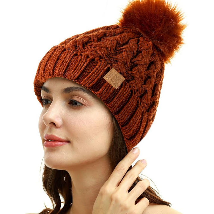 Front view of the Yvonne knit pom beanie, an essential piece of women's cold weather gear.