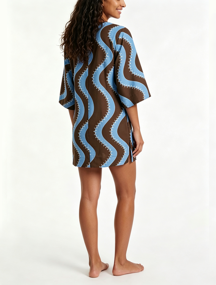 Model wearing a collared wave print mini dress, ideal for a casual brunch, vacation, or beach outing. Breezy shift style.