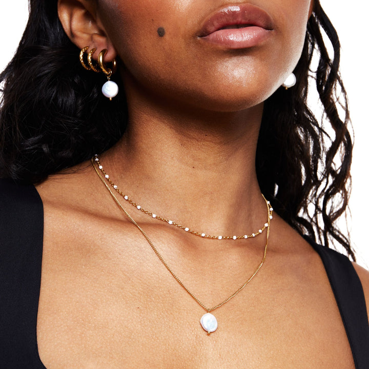 Close-up of white enamel beads on an elegant women's choker necklace. Fine detail.