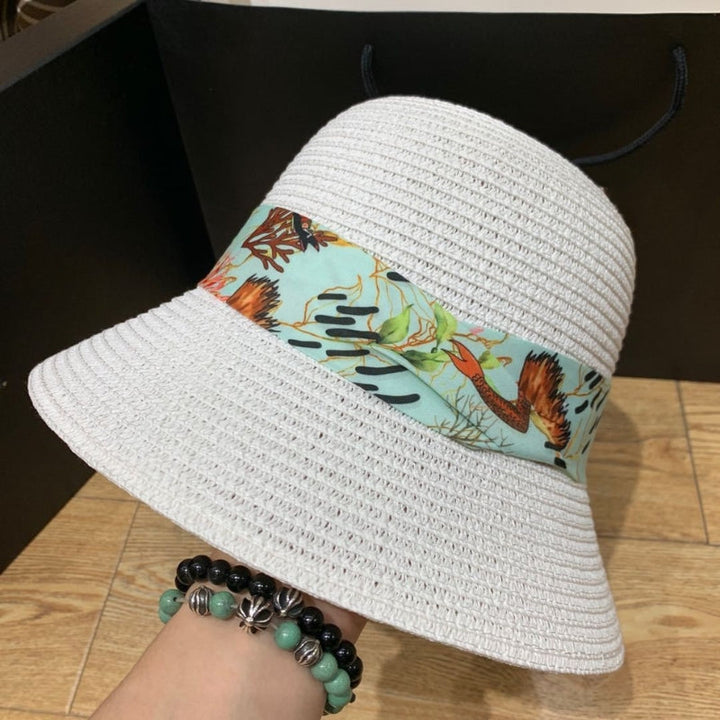 Women's wide brim sun hat with elegant black bow, perfect for beach or summer.