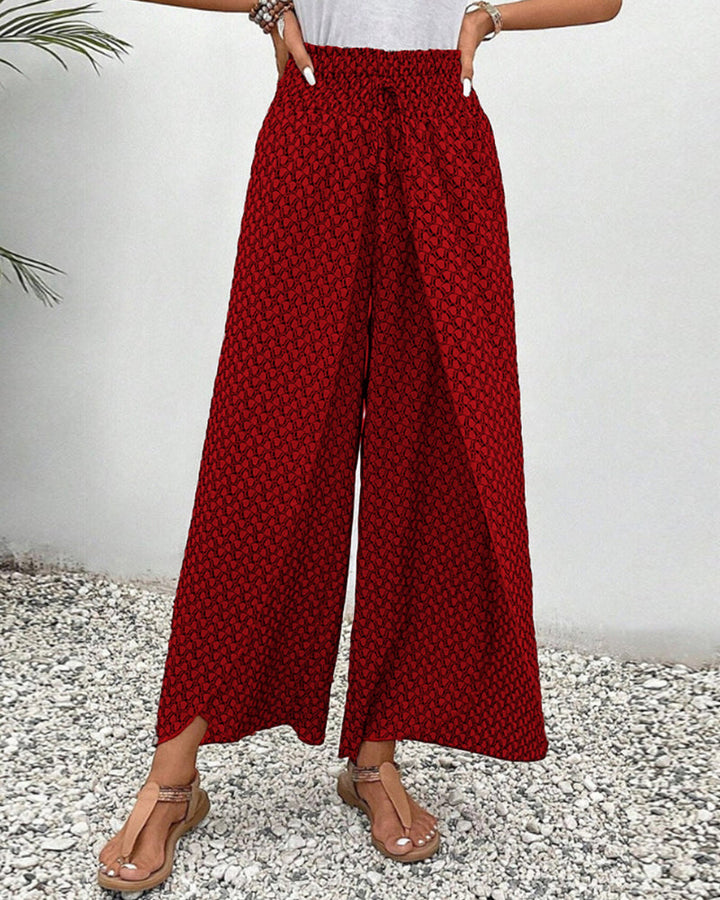 Full view of women's relaxed fit wide leg trousers in a vibrant geometric print. Day-to-night versatile.