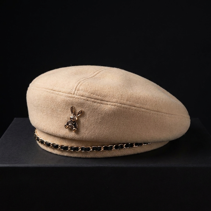 Women's wool blend baseball cap with sculptural gold bee emblem and chain accent, an elegant fashion accessory.