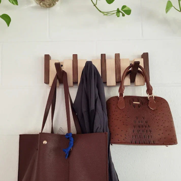 Close-up of wooden piano key coat rack, showing detailed craftsmanship and sturdy metal hooks